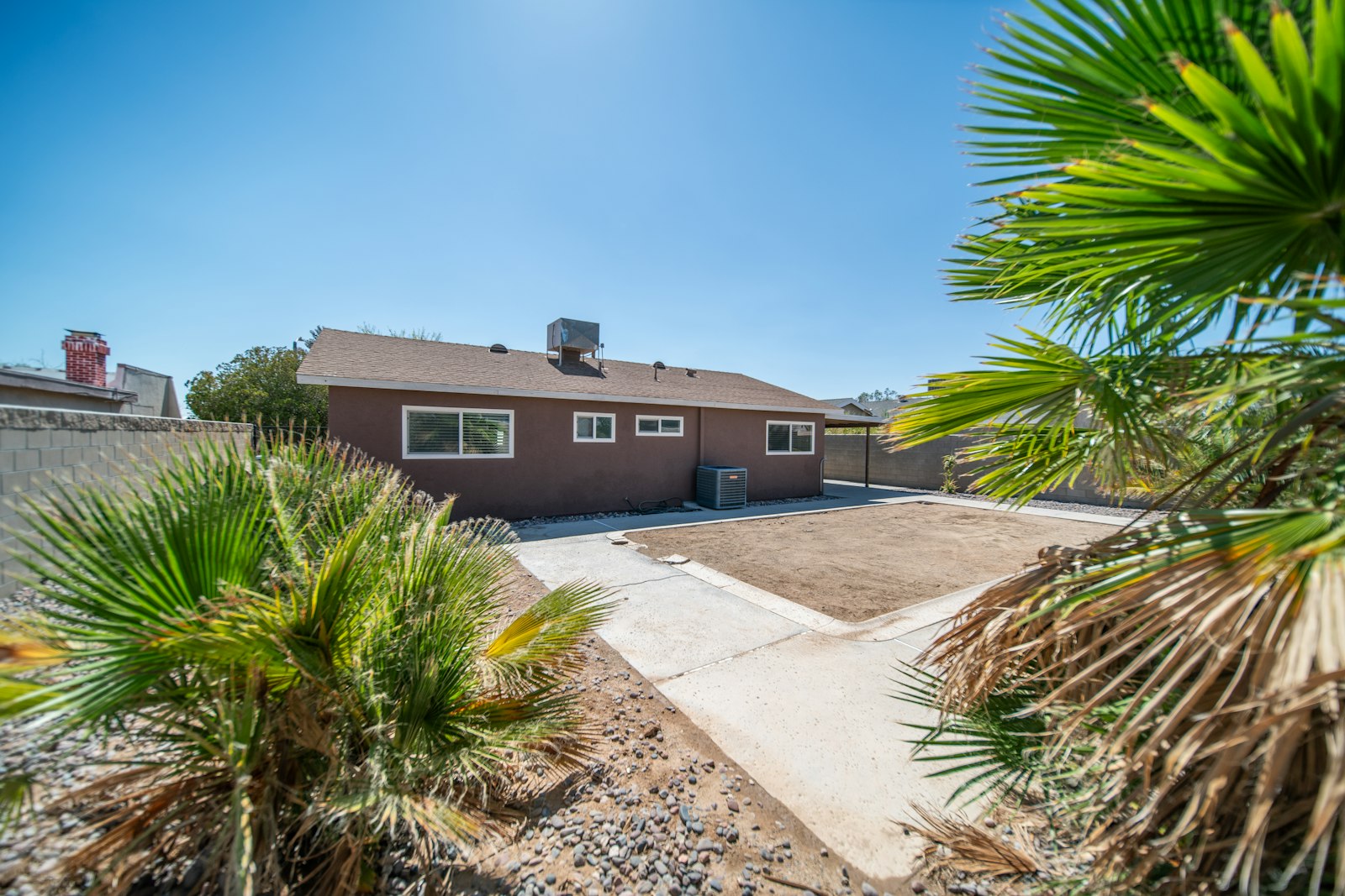 West Valley home with palm tree skirted clean and tidy front lawn.